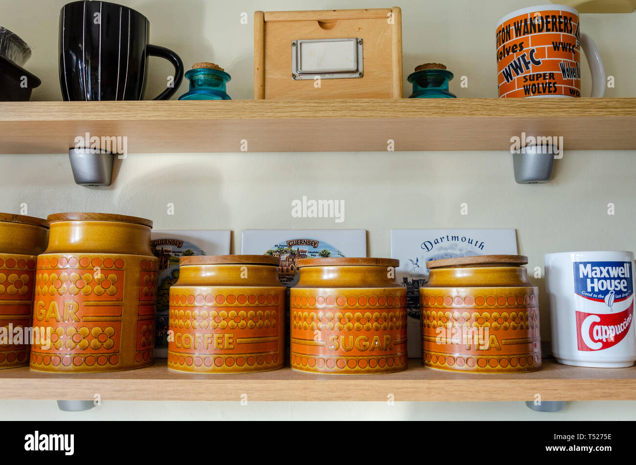Ripiani in un display da cucina Hornsea vasetti e Maxwell House tazze. Foto Stock