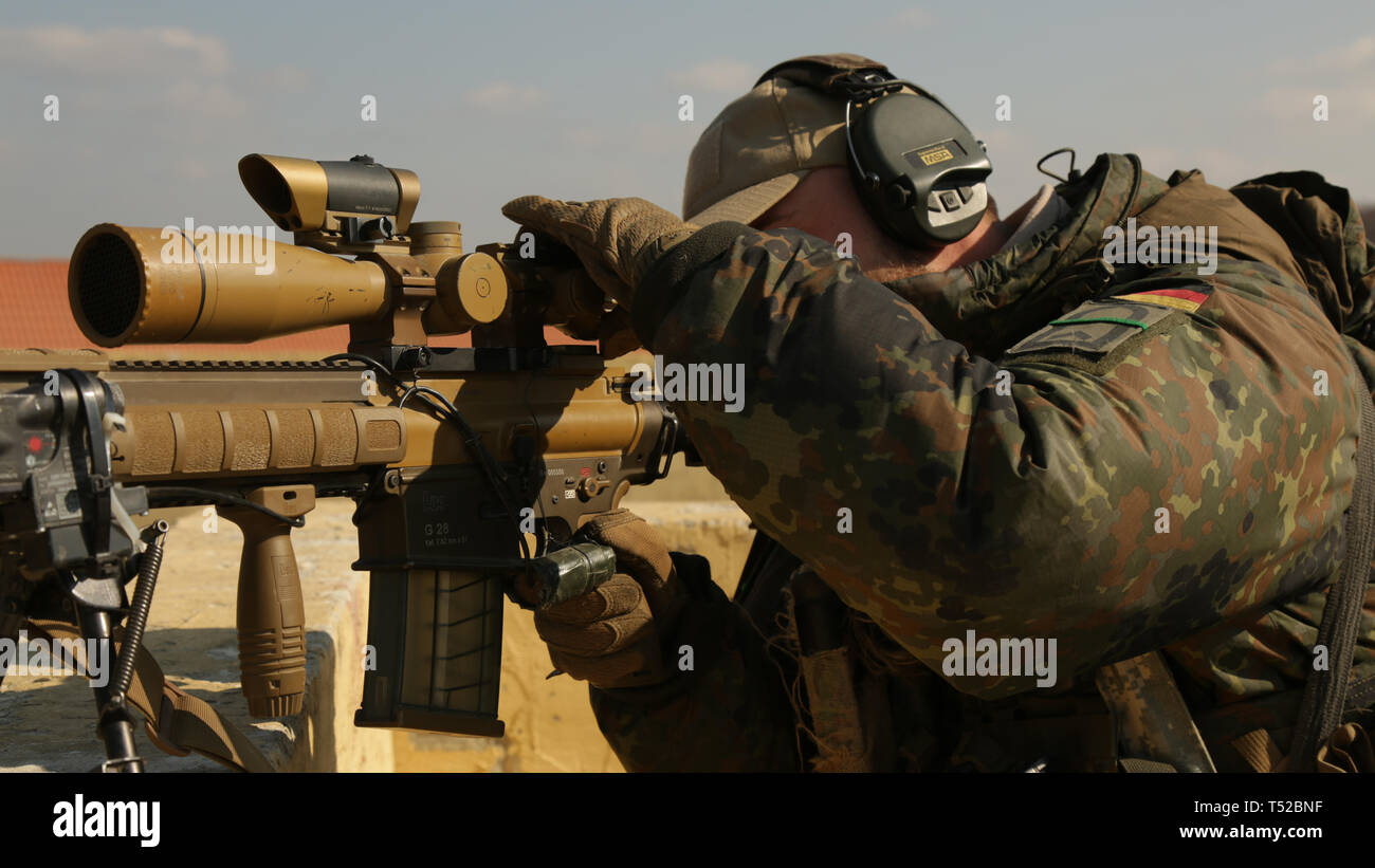 Un soldato tedesco si concentra la portata sul suo HK G28 durante l'esercizio Allied spirito X in Hohenfels, Germania, 12 aprile 2019. Esercizio Allied spirito X comprende circa 5.600 partecipanti provenienti da 15 nazioni, 30 marzo-aprile 17, 2019, alla settima Esercito di formazione del comando Hohenfels Area Formazione nel sud-est della Germania. Allied spirito è un U.S. Esercito Europa-diretto, 7 Esercito di formazione di Comando multinazionale condotta esercizio serie destinata a sviluppare e rafforzare la NATO e partner chiave di interoperabilità e disponibilità in tutta specificato le funzioni di combattimento. (U.S. Esercito foto di Spc. Dhy'Nysha James) Foto Stock