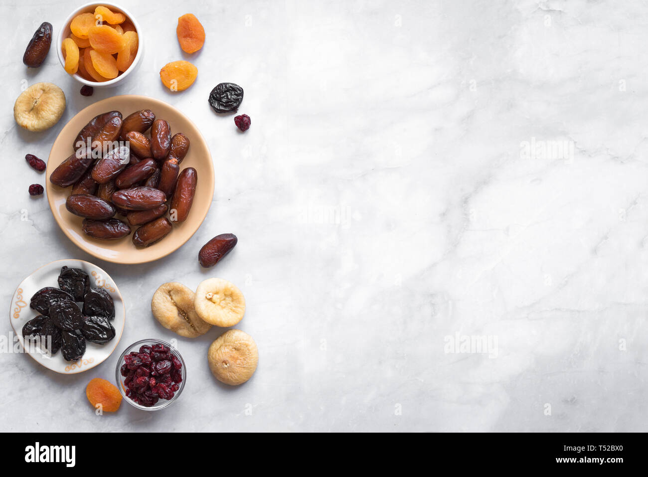 Frutta secca in ciotole su marmo bianco di sfondo, vista dall'alto, copia dello spazio. Snack sani - assortimento di organico frutta secca. Foto Stock