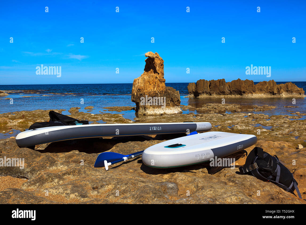 Inflateable tavole da surf sulle rocce al Los Arenetes in San Antonio riserva marina, Les Rotes, Denia, Spagna Foto Stock