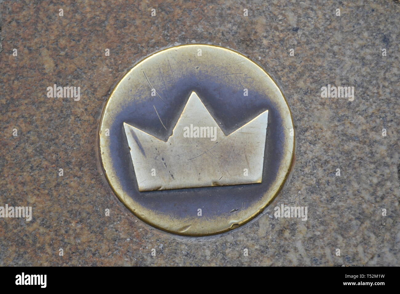 Piccolo Golden crown annegate nel pavimento della strada che indica il corso della royal entourage a una cerimonia di incoronazione Foto Stock