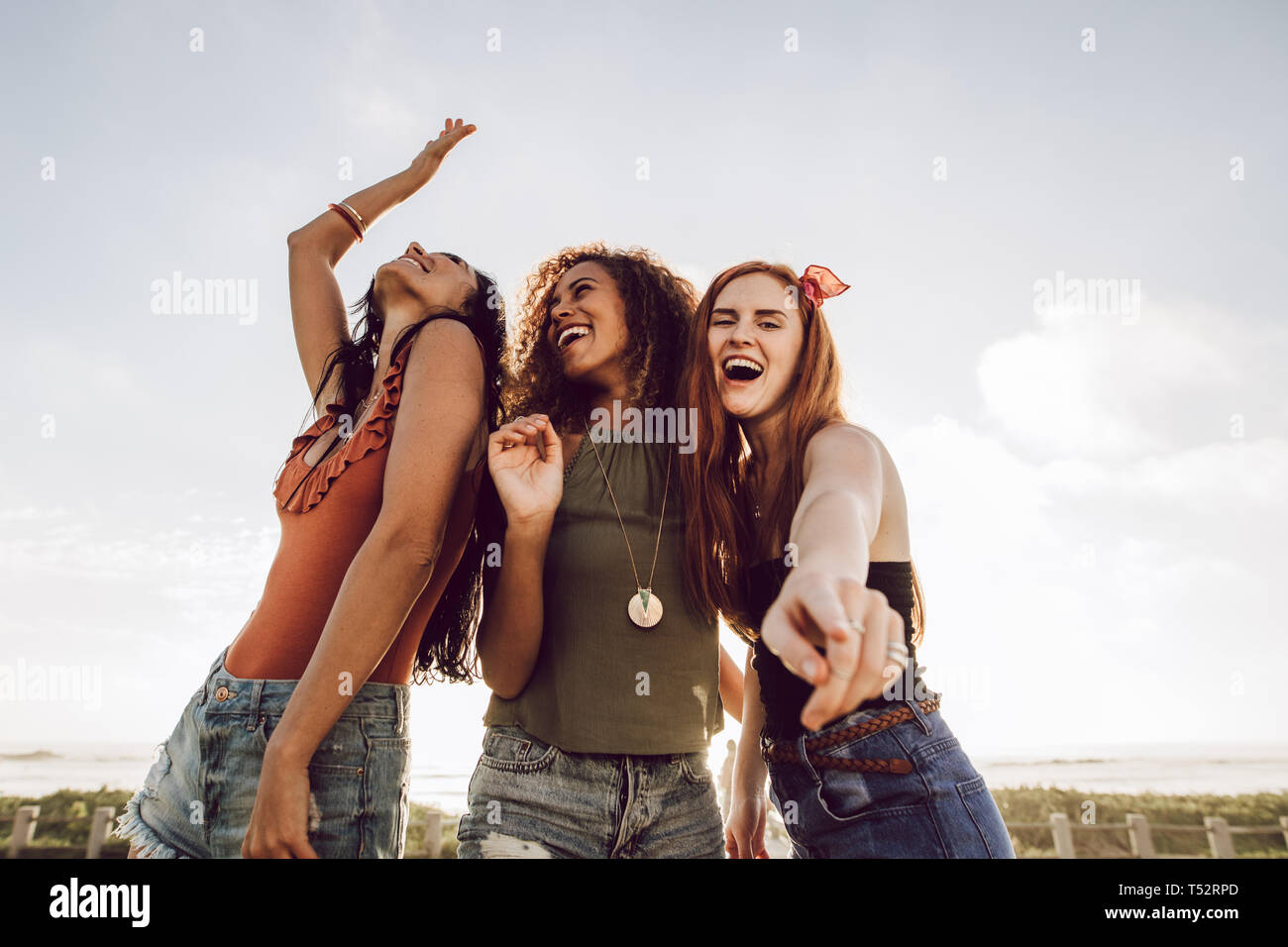 Gruppo di diversi amici di sesso femminile balli all'aperto. Tre donne aventi un grande tempo sulle loro vacanze estive. Foto Stock