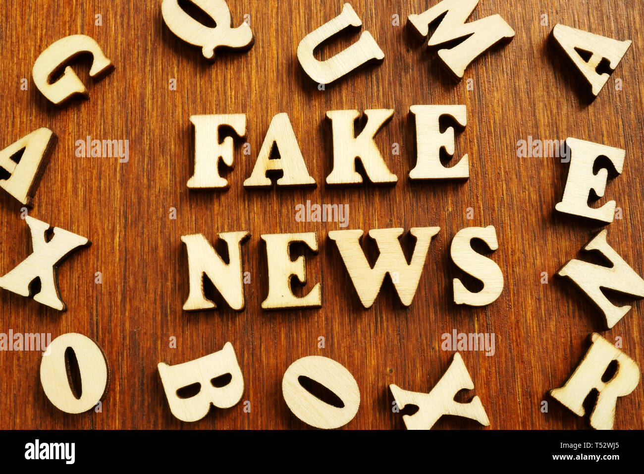 Fake news da lettere di legno sulla scrivania. Foto Stock