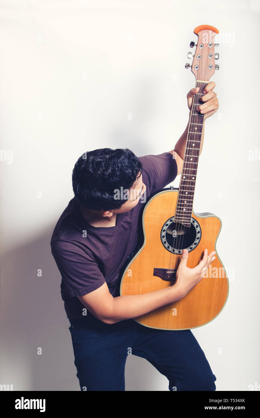 L'uomo gioca chitarra acustica su sfondo bianco close up shot Foto Stock
