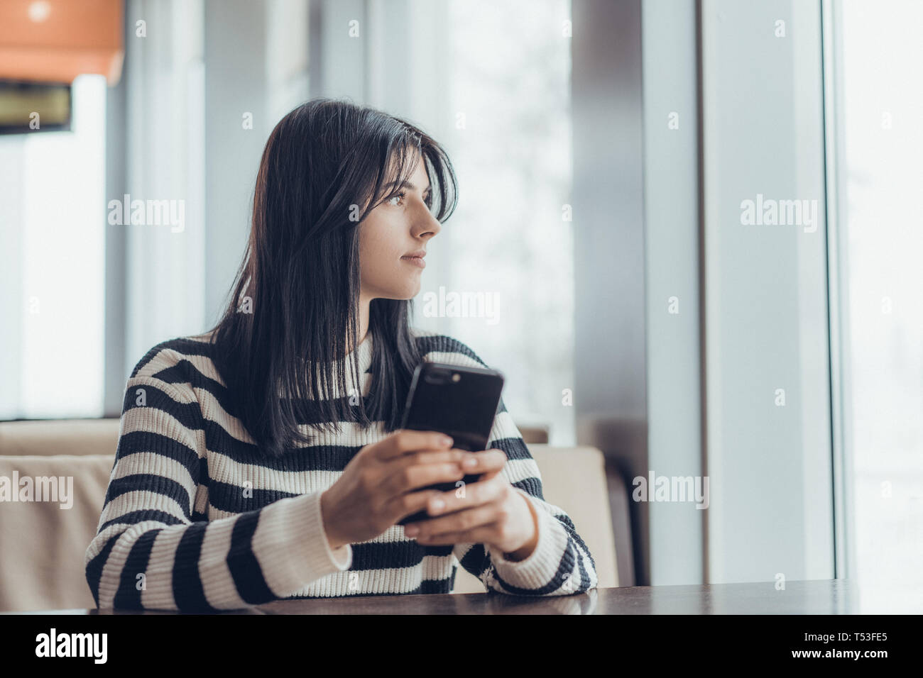 Smart phone tenendo in mano femmina e prendere un caffè. Foto Stock