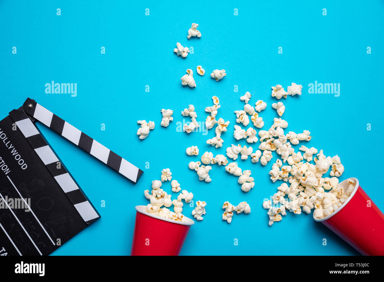 Cinema per due concept. Salate fresche pop corn e movie clapper board, blu colore di sfondo, vista dall'alto Foto Stock