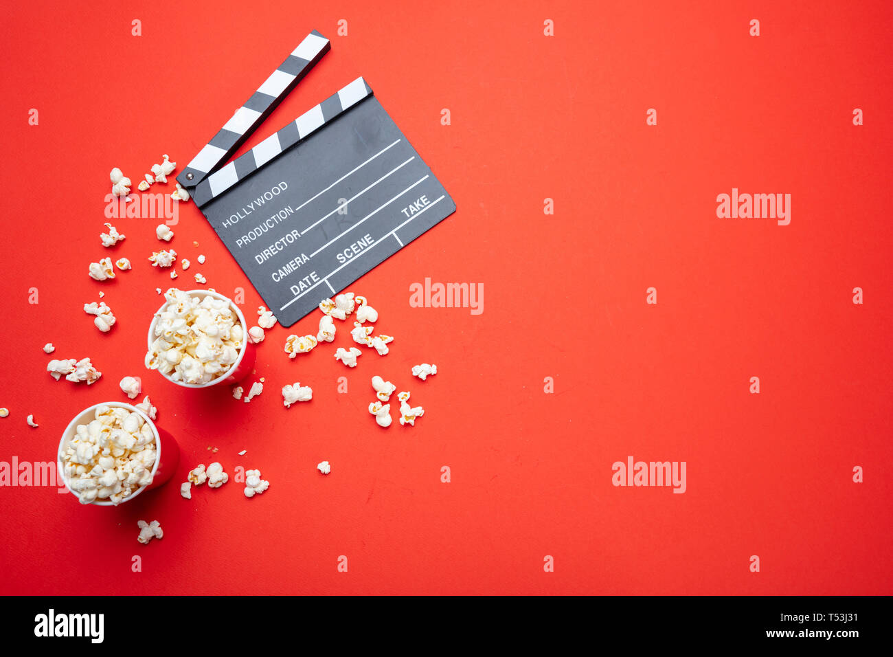 Cinema per due concept. Salate fresche pop corn e movie clapper bordo rosso, colore di sfondo, vista dall'alto Foto Stock