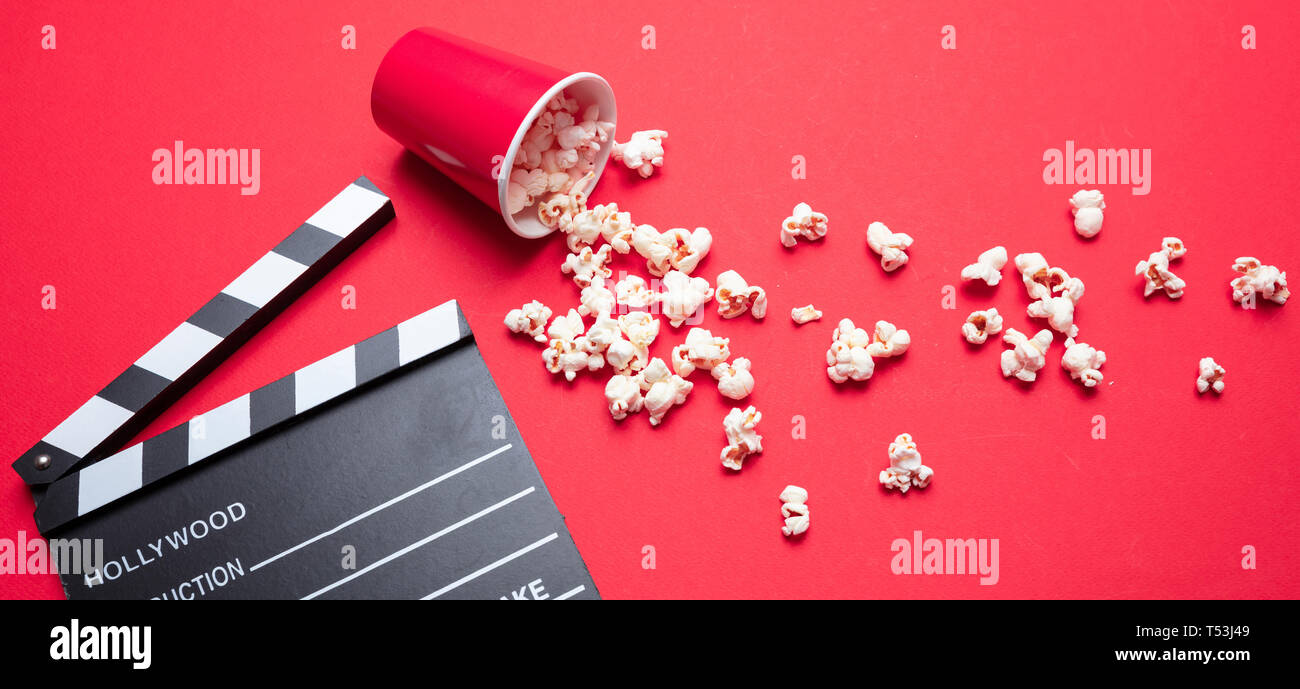 Cinema concetto. Salate fresche pop corn e movie clapper bordo rosso, colore di sfondo, banner Foto Stock