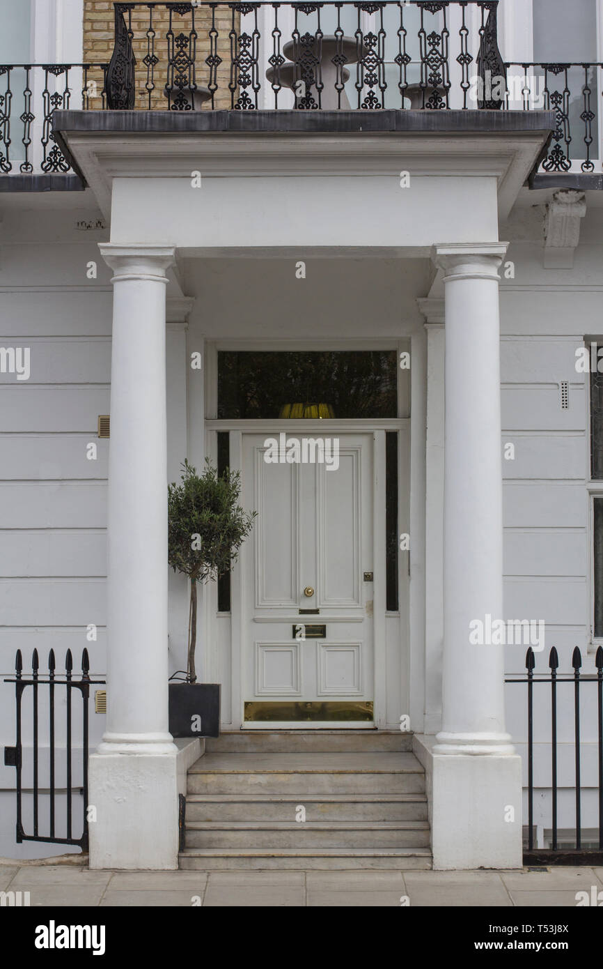 Legno bianco porta di ingresso al palazzo residenziale a Londra. Tipica porta in stile inglese. Foto Stock