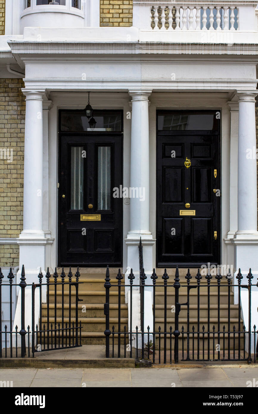 Due neri di porte in legno per edilizia residenziale a Londra. Tipica porta in stile inglese. Foto Stock