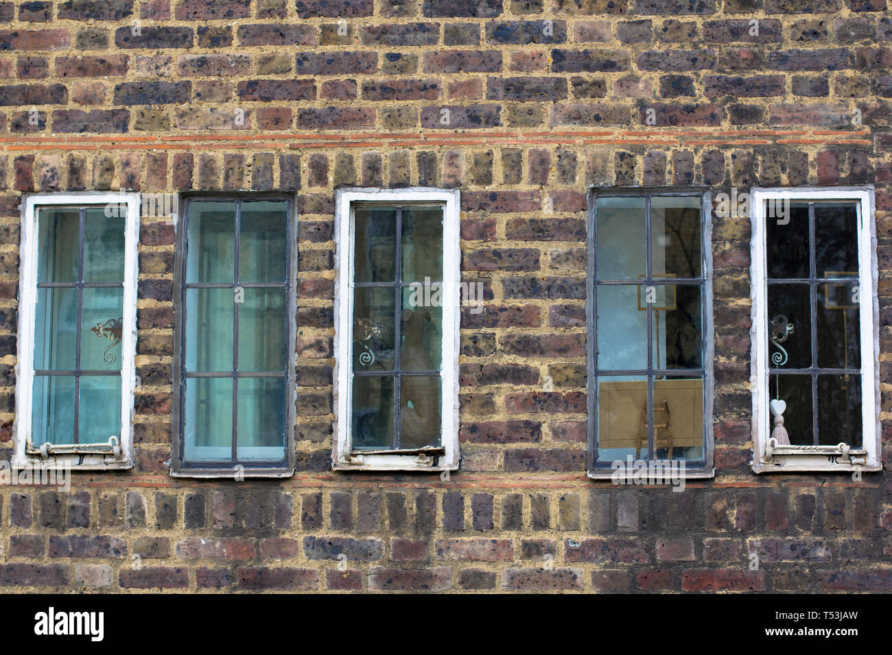 Diversi piccoli vintage windows in un mattone antico muro. Foto di strada. Foto Stock