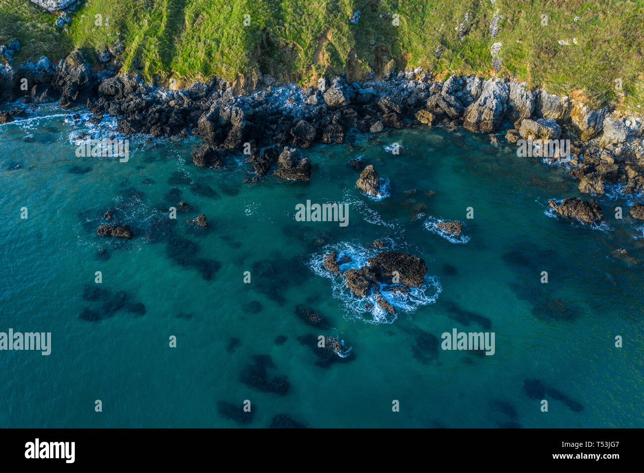 Mare di onde che si infrangono sulla barriera corallina e sulla costa di Sonabia, Spagna Mare cantabrico - drone vista aerea Foto Stock
