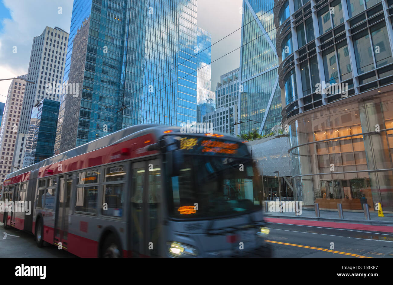 Bus in movimento su strada del centro cittadino di San Francisco, con la città di edifici in background, California, Stati Uniti. Foto Stock