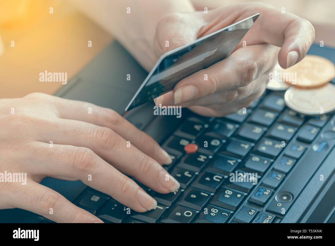 Business donna le mani sul computer portatile con bitcoin su tasti e card per acquistare bitcoin. Abstract: shopping online. Effetto colore. Foto Stock