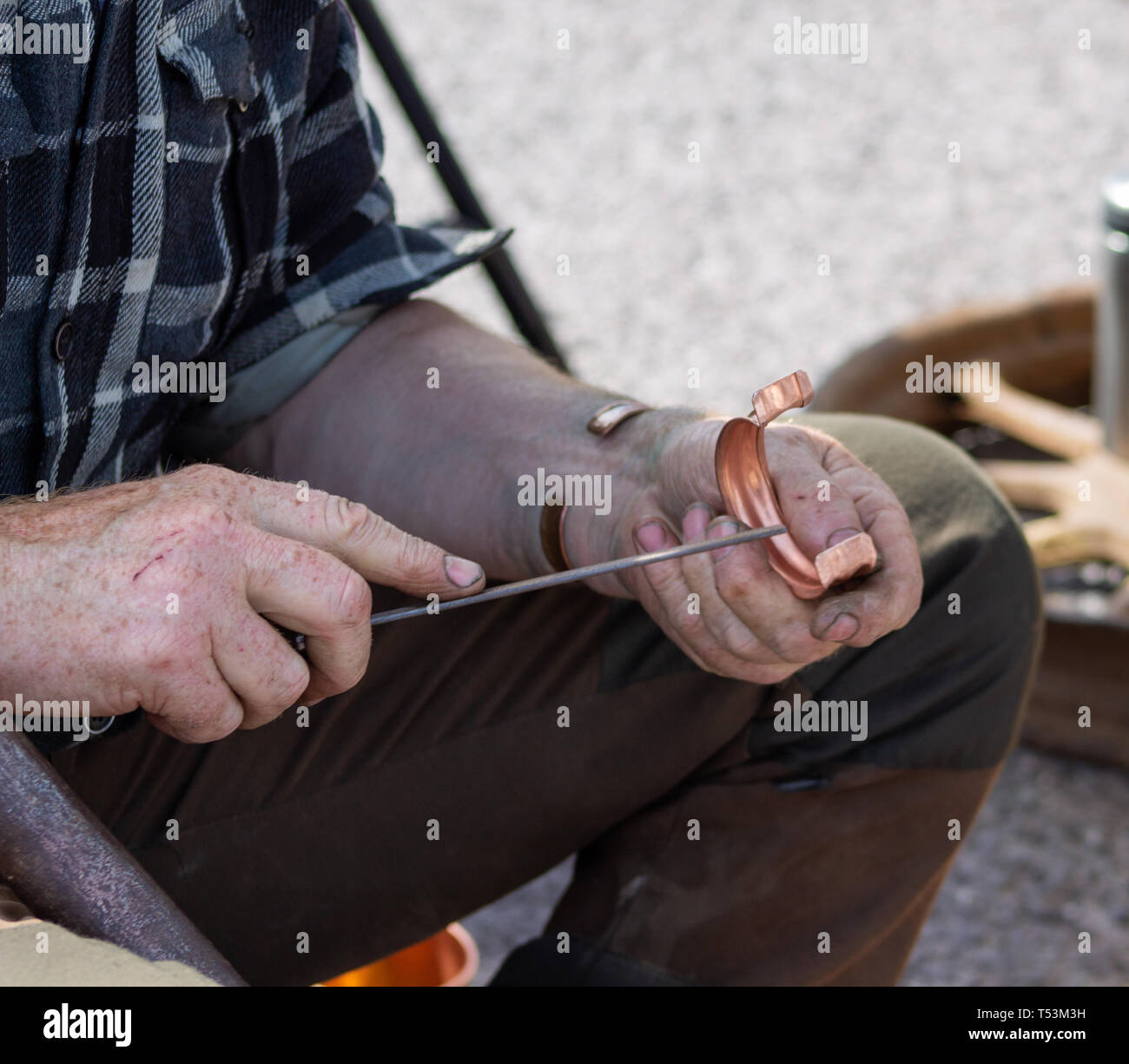 Ramaio lavoratore in metallo facendo un braccialetto di rame con utensili a mano Foto Stock
