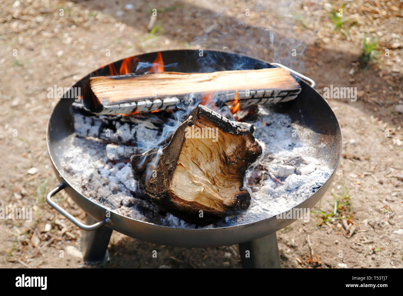 Feuer in einer Feuerschale, großer Holzgrill mit Asche Foto Stock
