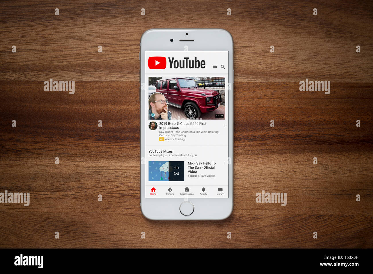 Un iPhone che mostra il sito web YouTube poggia su una semplice tavola di legno (solo uso editoriale). Foto Stock