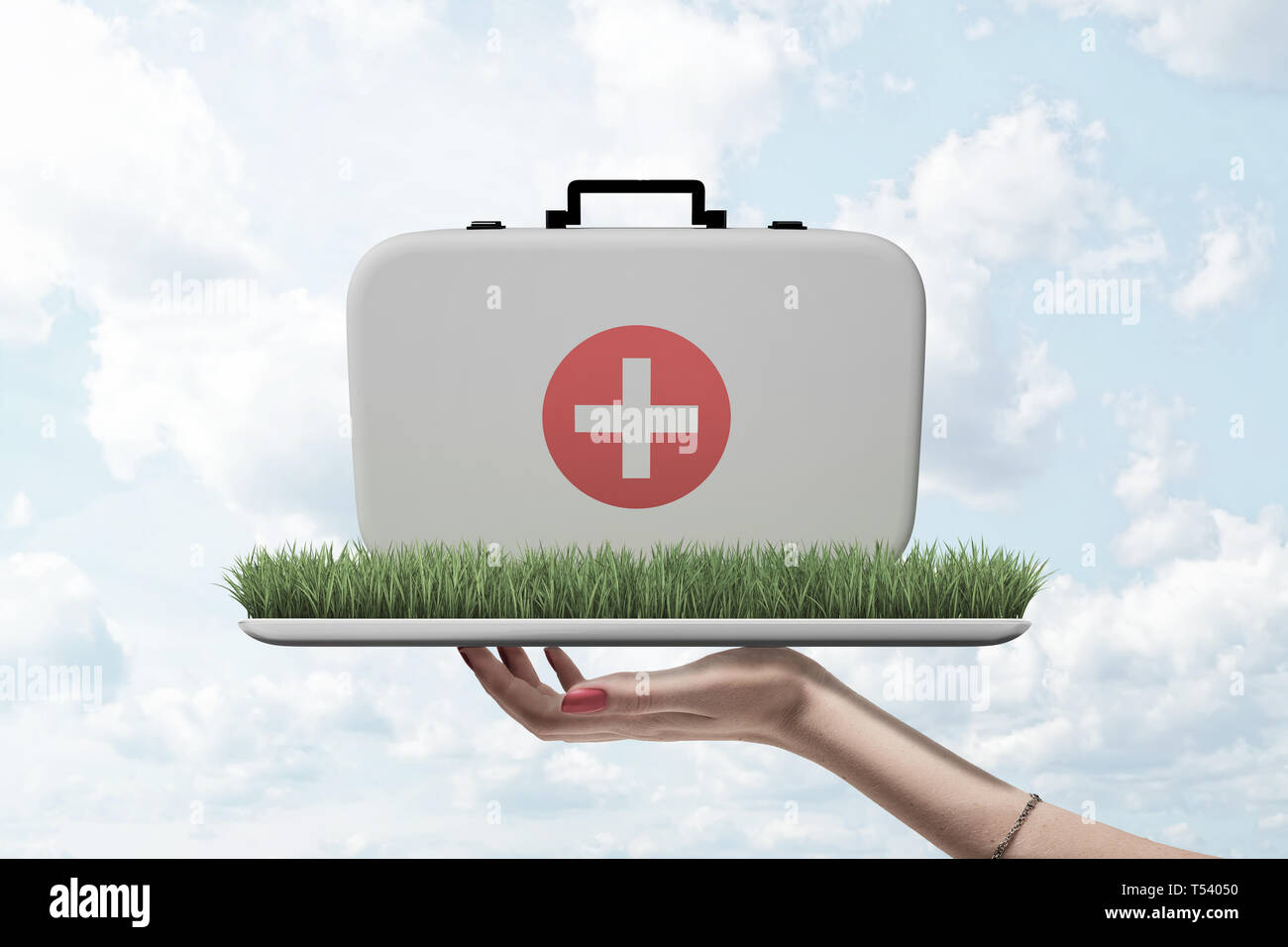 Vista laterale della donna di mano tenendo il vassoio con la patch di erba verde su di esso con il medico per caso sulla parte superiore contro il cielo nuvoloso. Foto Stock