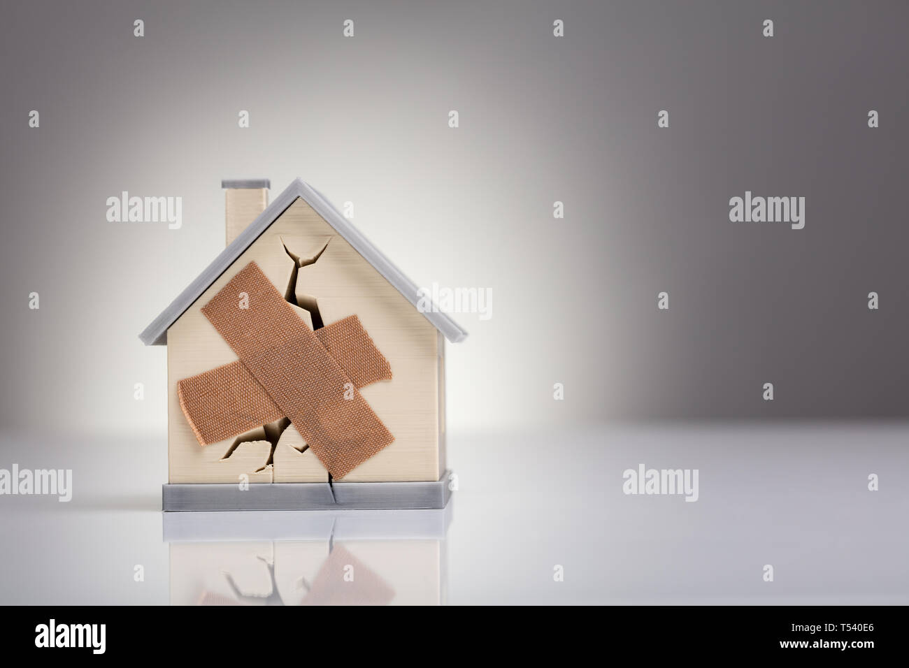 Casa rotto modello con banda incrociati Aiuto sulla scrivania Foto Stock