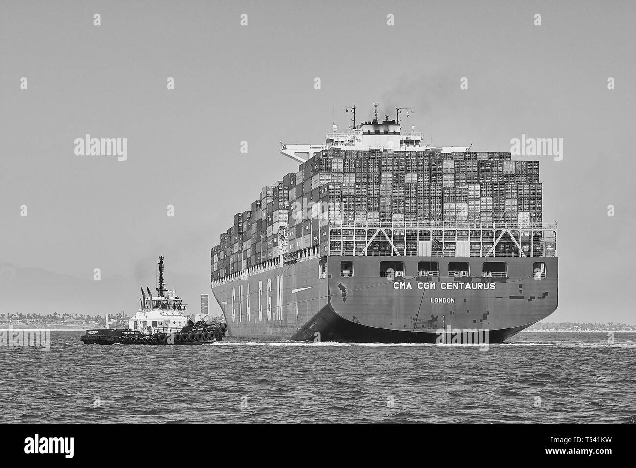Bianco & Nero Foto della nave portacontainer CMA CGM CENTAURO, essendo ruotata di 180 gradi da 2 rimorchiatori prima di approdare a Long Beach, California, Stati Uniti d'America Foto Stock