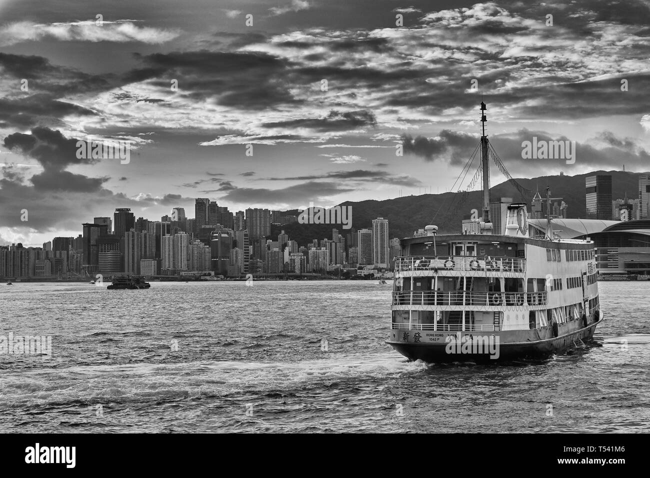 Foto Moody in bianco e nero del traghetto passeggeri e Victoria Harbour, Hong Kong, poco dopo l'alba. Foto Stock