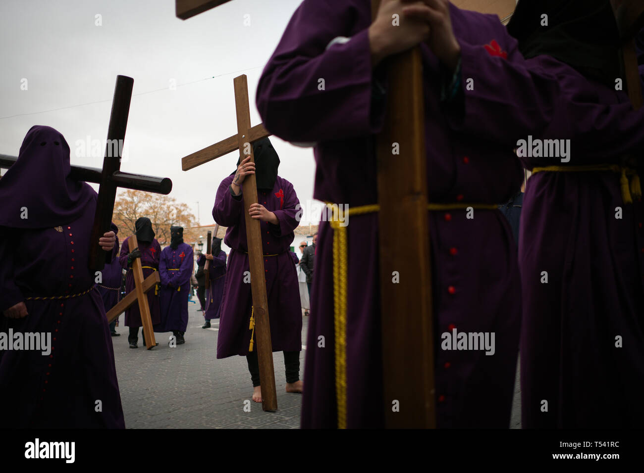 Un gruppo di penitenti con le loro croci sono in attesa per il Venerdì Santo Processione per iniziare. Foto Stock