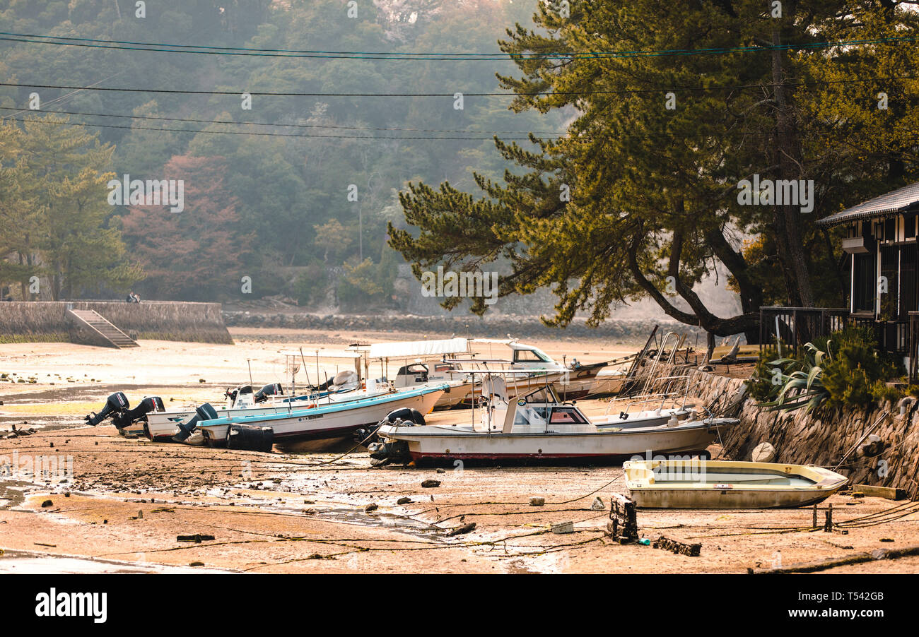 Barche a terra con la bassa marea sull'isola di Miyajima, Giappone Foto Stock