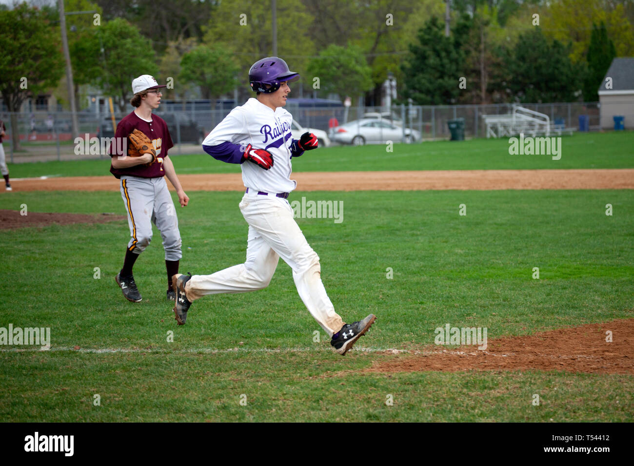 Teenage giocatore di baseball in esecuzione per la prima base in corrispondenza del Cretin-Derham Hall school home campo. St Paul Minnesota MN USA Foto Stock