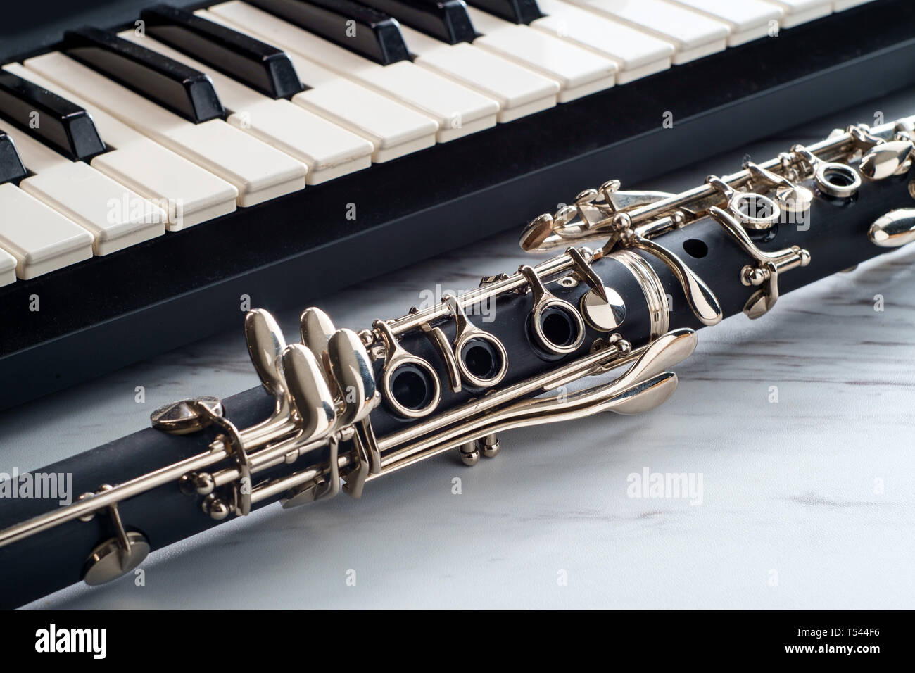 Vecchio arrugginito clarinetto classico sulla tavola di marmo vicino al  pianoforte elettrico tastiera Foto stock - Alamy