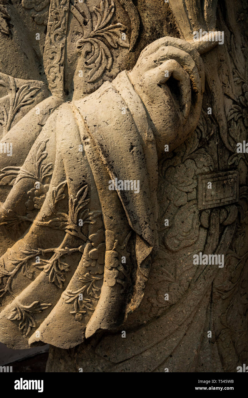 Thailandia, Bangkok, Wat Pho, Phra Chedi Rai, scolpita la figura dettaglio del costume e gesticolando mano con ornati in accappatoio Foto Stock