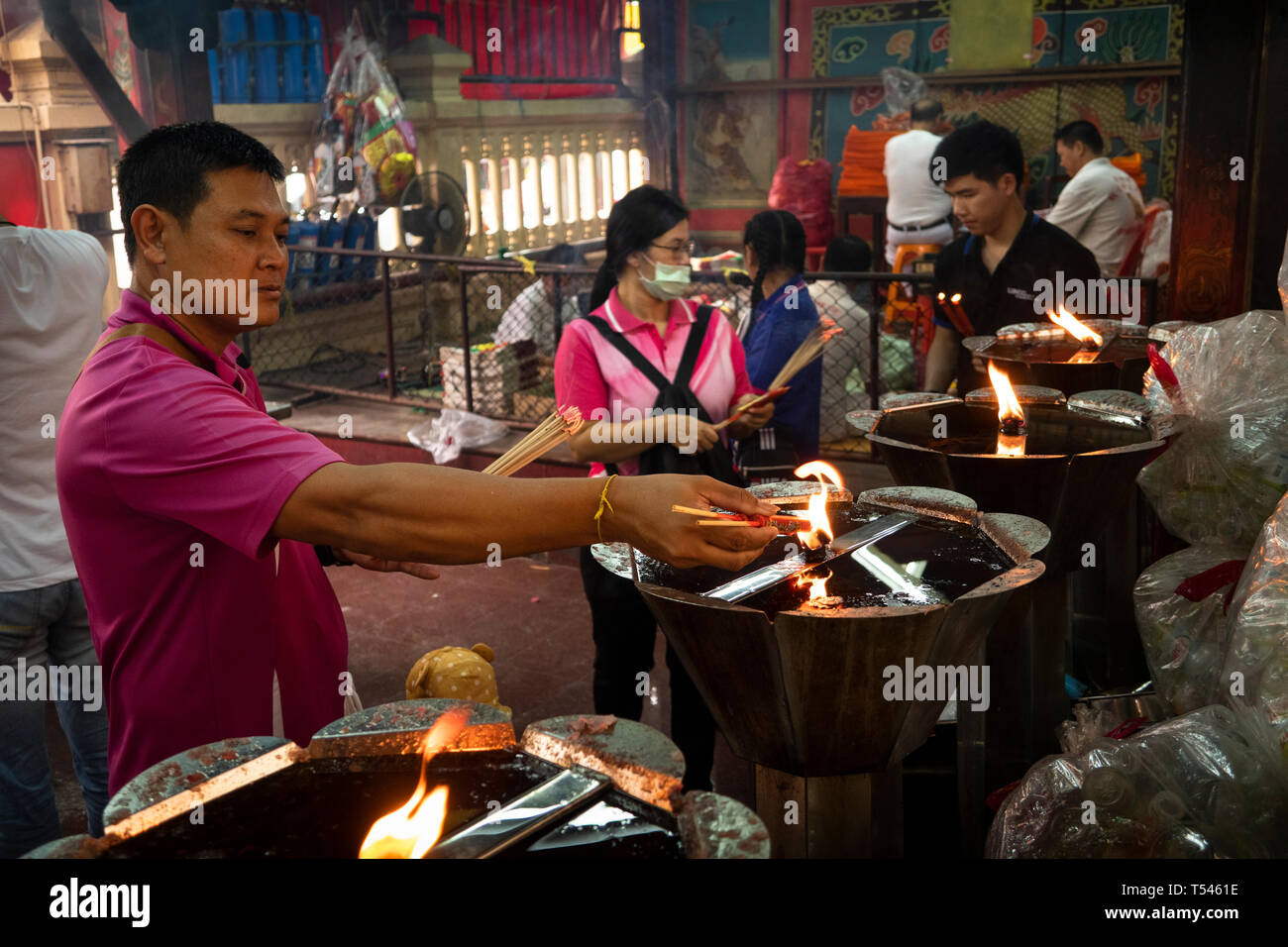 Thailandia, Bangkok, Thanon Tanao, Khwaeng San Chao Pho Sua, Xuantian Shangdi tempio, adoratore di illuminazione bastoncini di incenso su fiamma aperta Foto Stock