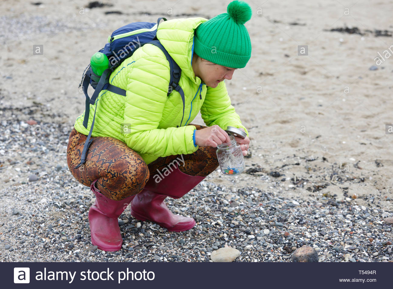 Spiaggia pulita fino, volontari cercando e raccogliendo microplastics nocivi e metterli in un vasetto per lo smaltimento sicuro Foto Stock