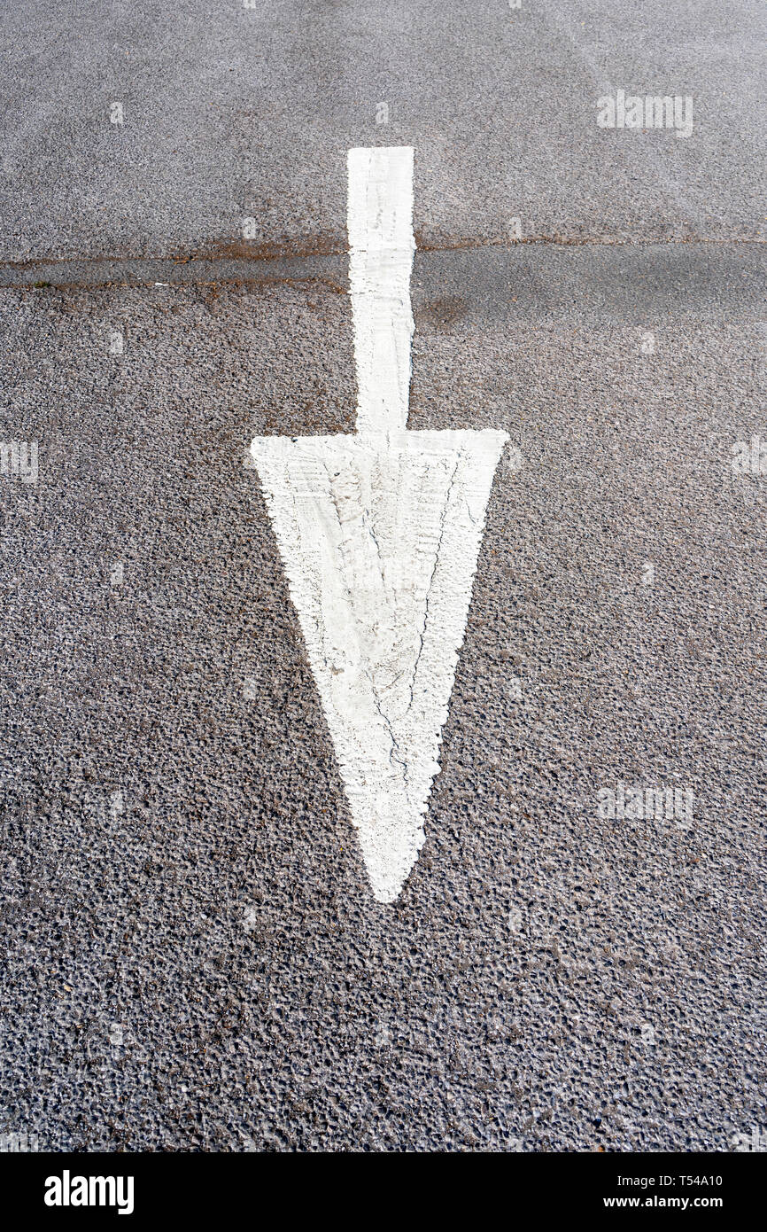 Dipinto di bianco freccia sulla superficie stradale Foto Stock