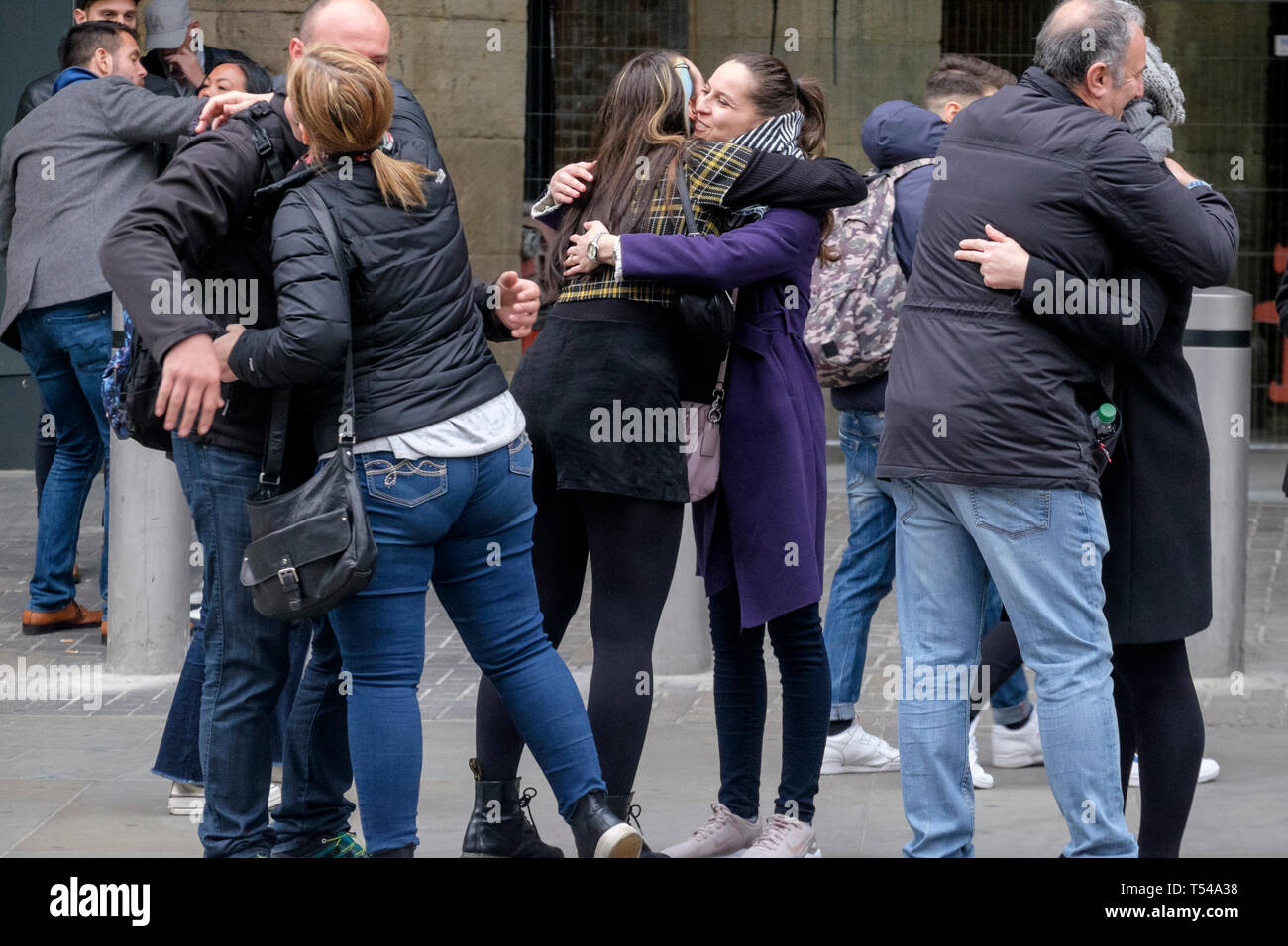 Un gruppo di persone abbracciare come si incontrano in London street. Foto Stock