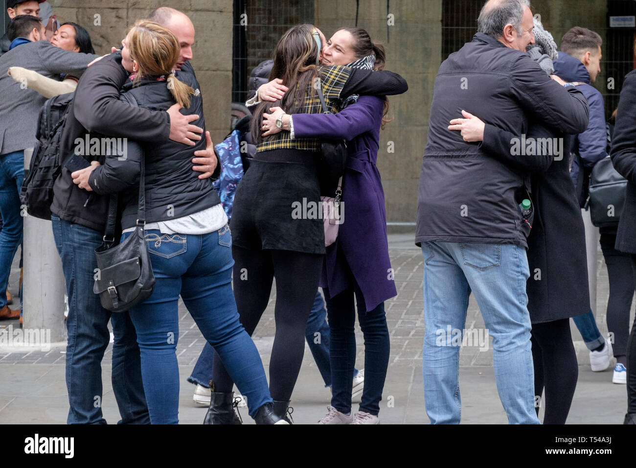 Un gruppo di persone abbracciare come si incontrano in London street. Foto Stock