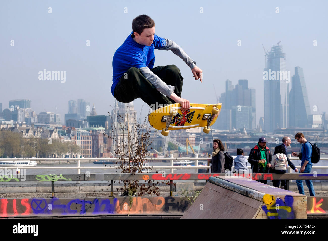 Skateboarder sul Waterloo Bridge sullo sfondo della City of London. Foto Stock