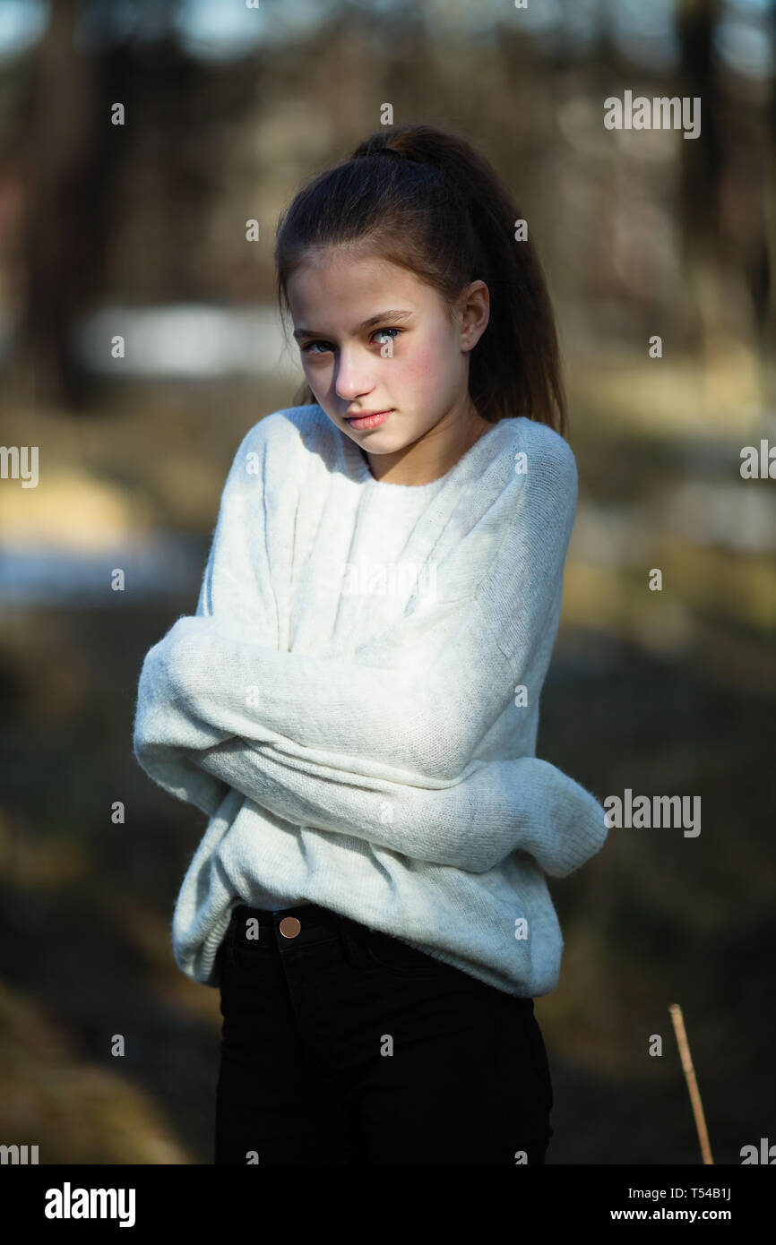 Carino ragazza di dodici anni nel parco in posa per la fotocamera. Foto Stock