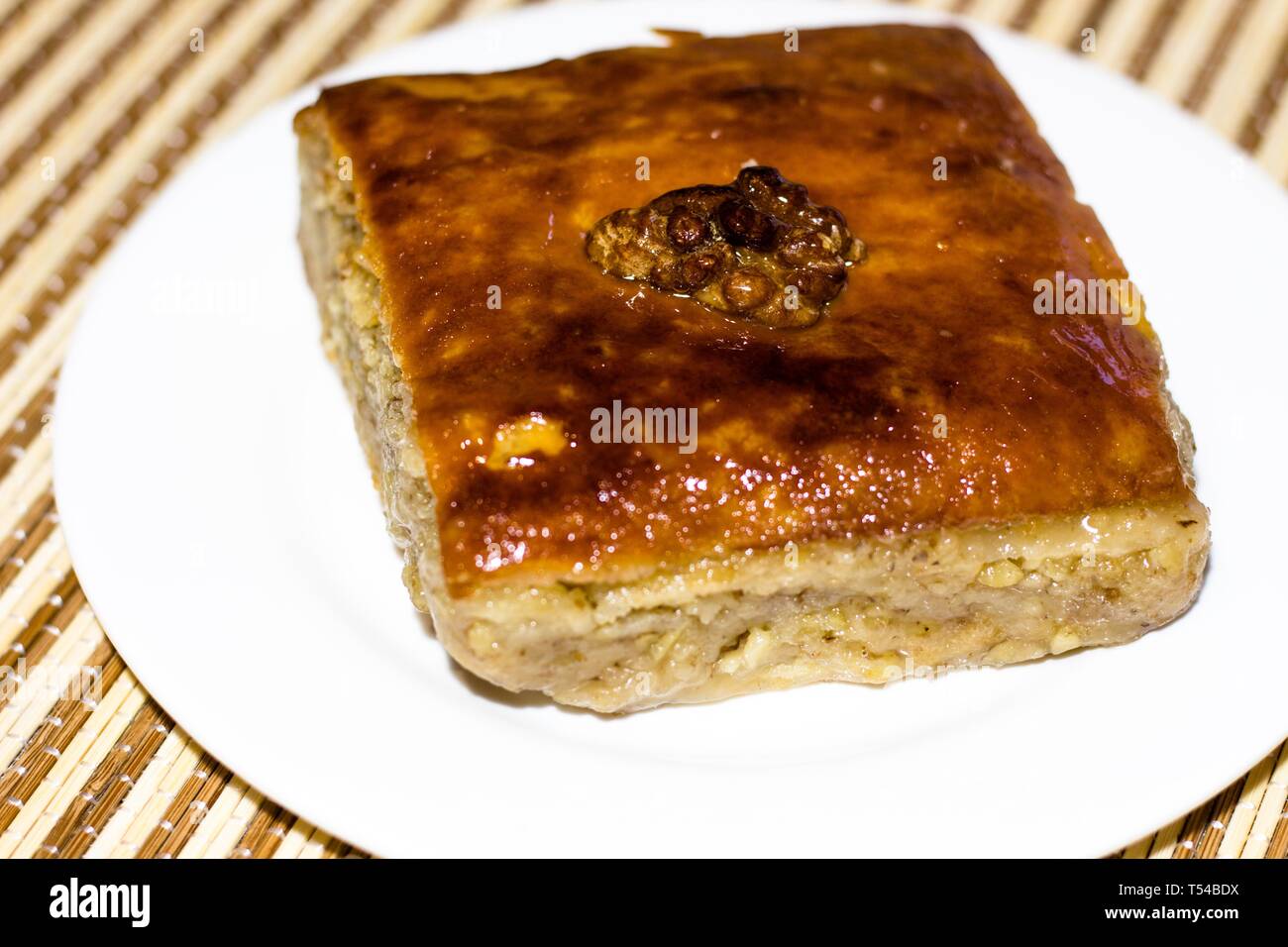 Una deliziosa pasticceria fresca con miele e noci su uno sfondo bianco chiamato Baklava. Delizioso e sano dessert per bere il tè. Foto Stock