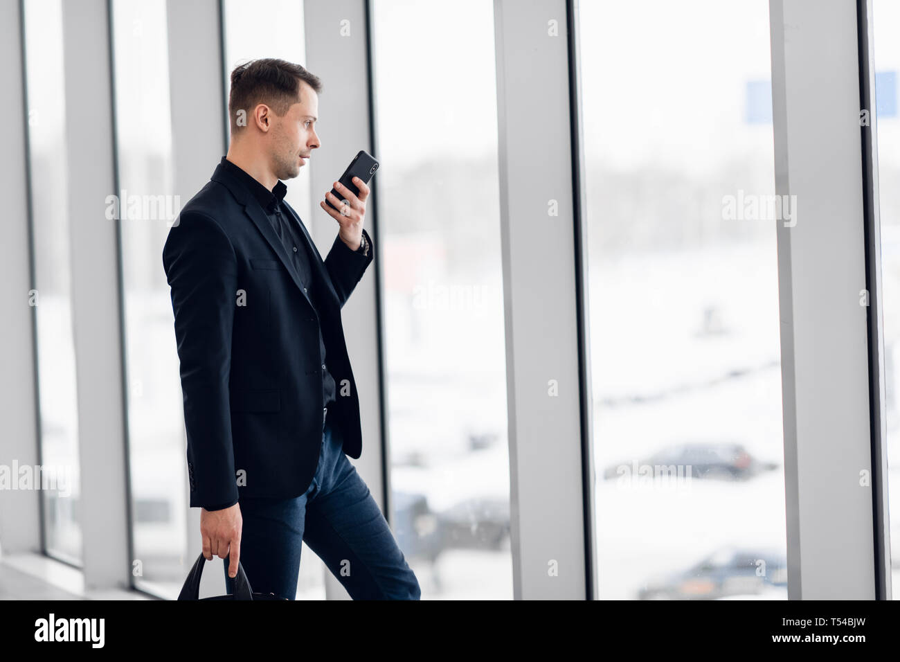 Imprenditore concentrato la registrazione del messaggio vocale in aeroporto Foto Stock
