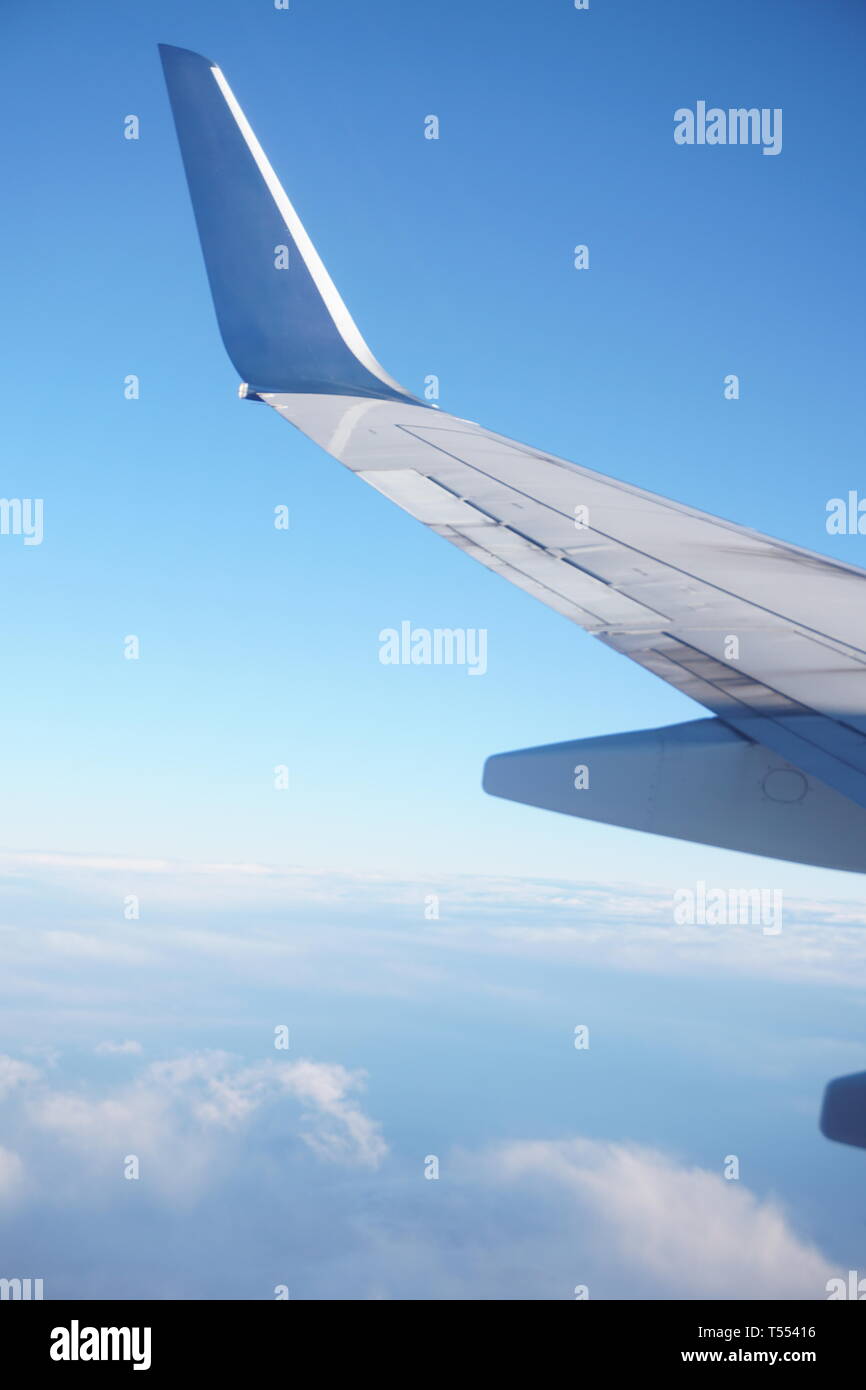 Ala di aeroplano dalla finestra aereo sopra le nuvole nel cielo. Foto Stock