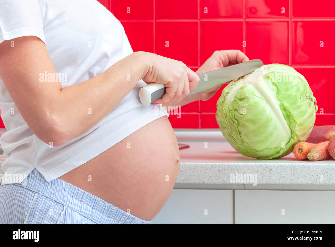 Donna incinta la preparazione di alimenti Foto Stock