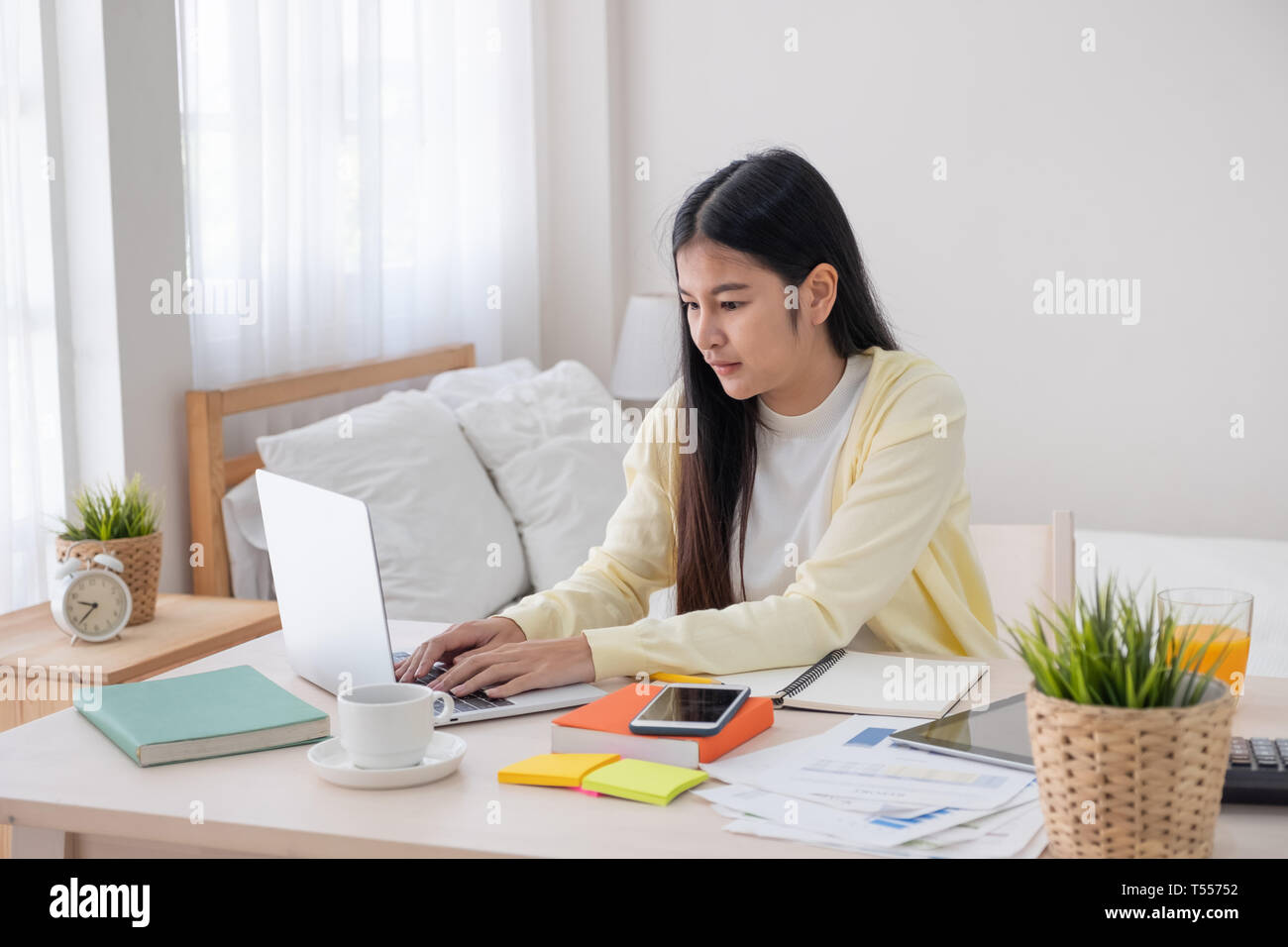 Femmina asiatica freelancer lavorando sul computer portatile sul tavolo in camera da letto a casa.lavoro lifestyle online.il lavoro a casa. Foto Stock