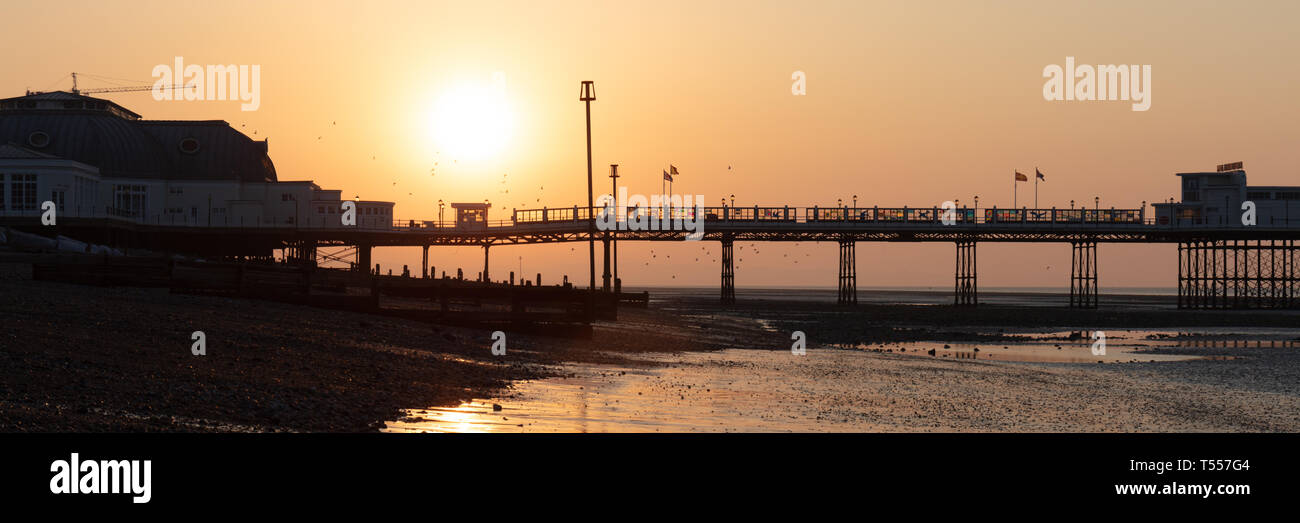 Worthing Sussex, Regno Unito; xx aprile 2019; Dawn con il sorgere del sole dietro a Worthing Pier a bassa marea Foto Stock