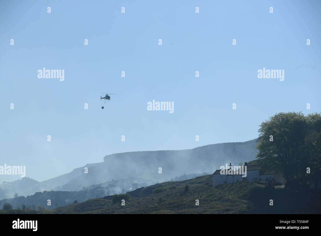 Vigili del fuoco utilizza un elicottero a goccia acqua come essi affrontare un incendio di grandi dimensioni che continua a bruciare a Ilkley Moor nel West Yorkshire. Foto Stock