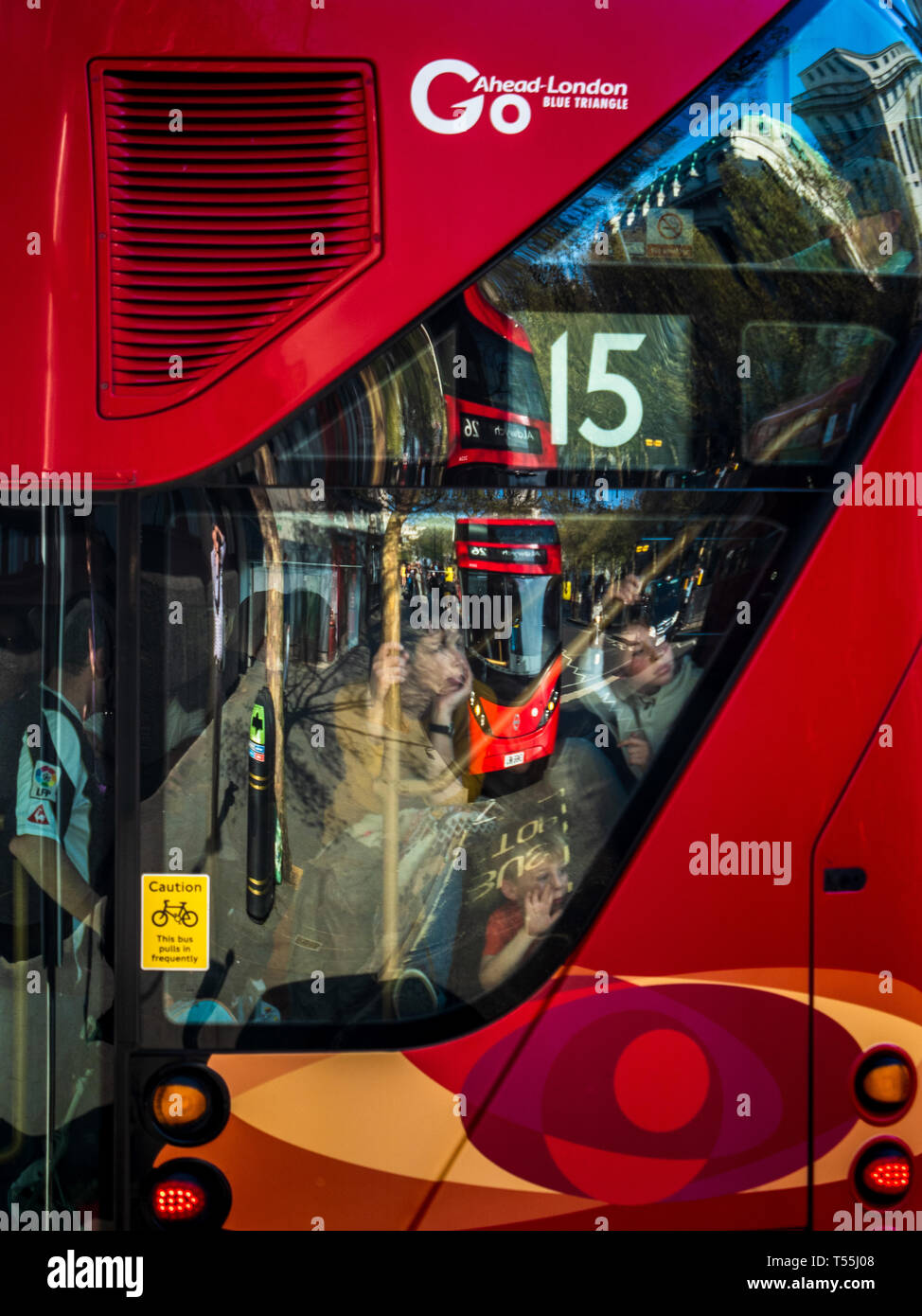 I bambini guardano al di fuori della scala posteriore finestra di una nuova Londra Routemaster Bus con un altro autobus riflessa nella finestra . Foto Stock