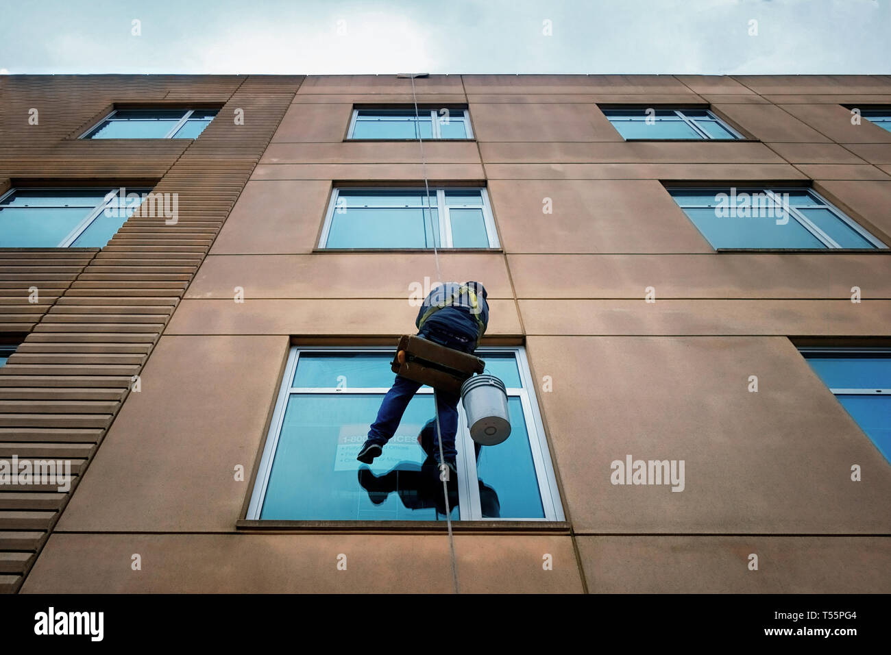 L'uomo appeso ad una fune di windows di lavaggio. Foto Stock