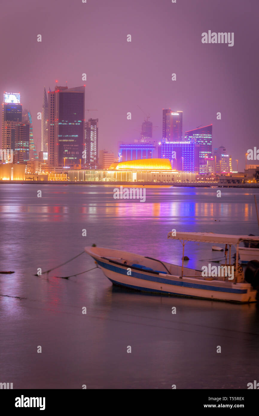 Ormeggiato in motoscafo da skyline della città di notte in Manama, Bahrain Foto Stock