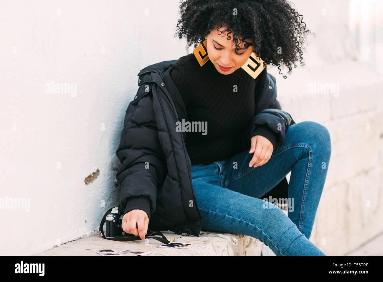 Giovane donna fotografie di smistamento su banco Foto Stock