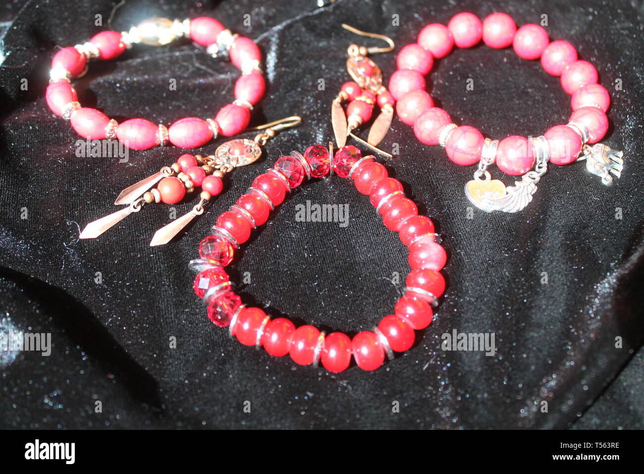 Rosso brillante bracciale con orecchini e candela rossa per lo zen e la guarigione e la meditazione Foto Stock