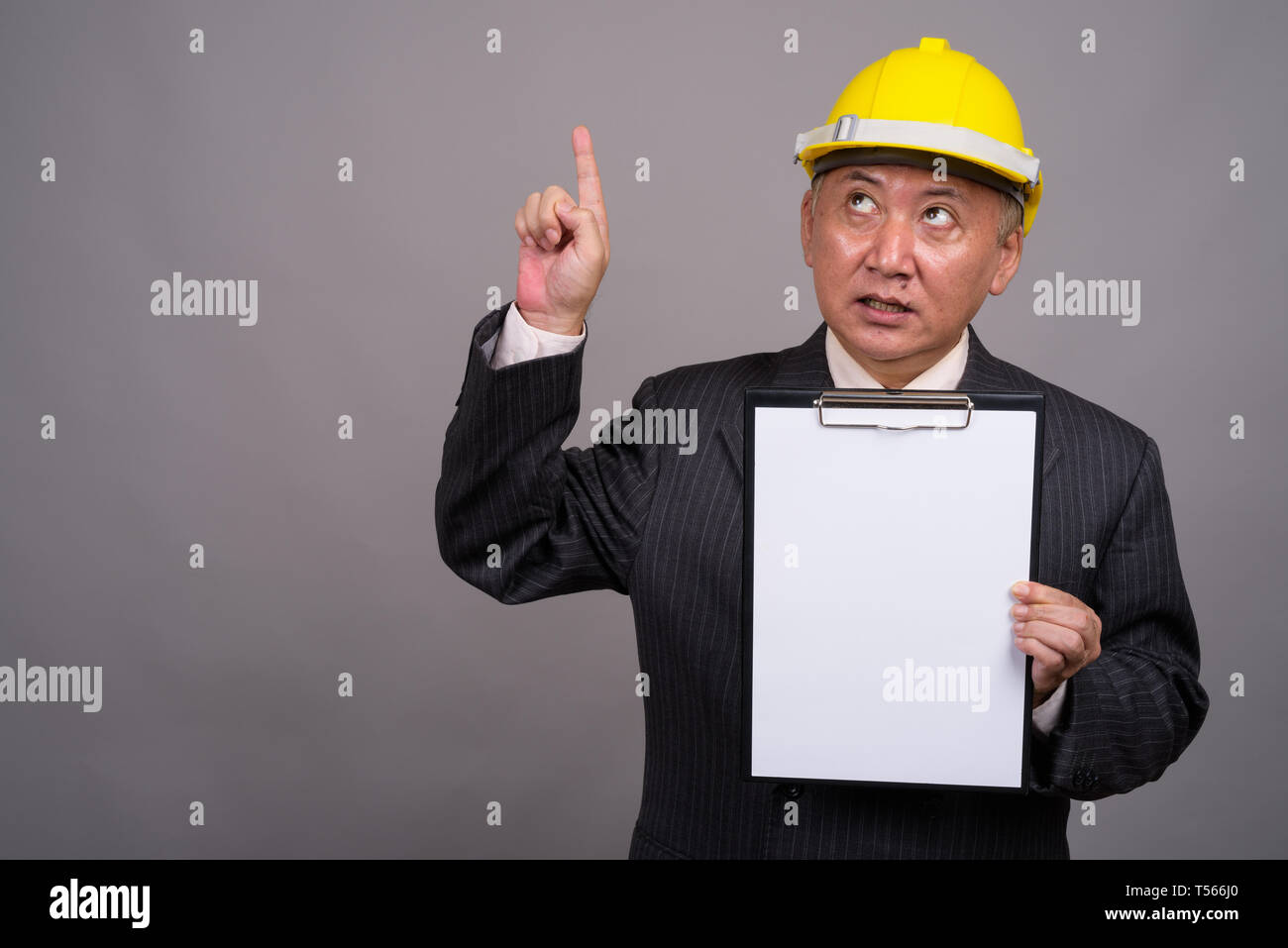 Coppia asiatica imprenditore di costruzione contro uno sfondo grigio Foto Stock